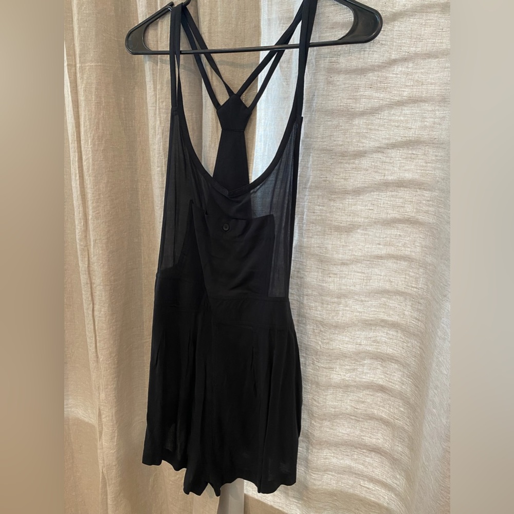 Black romper. Overall fit. Sheer top. Small front pocket. Strappy back. M